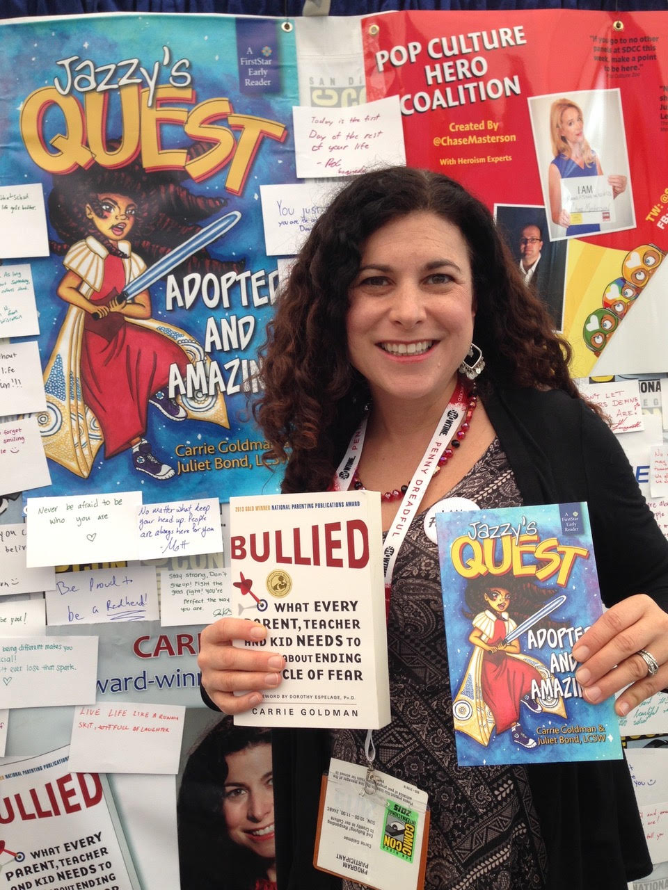 Carrie Goldman holding up her books at San Diego Comic-Con